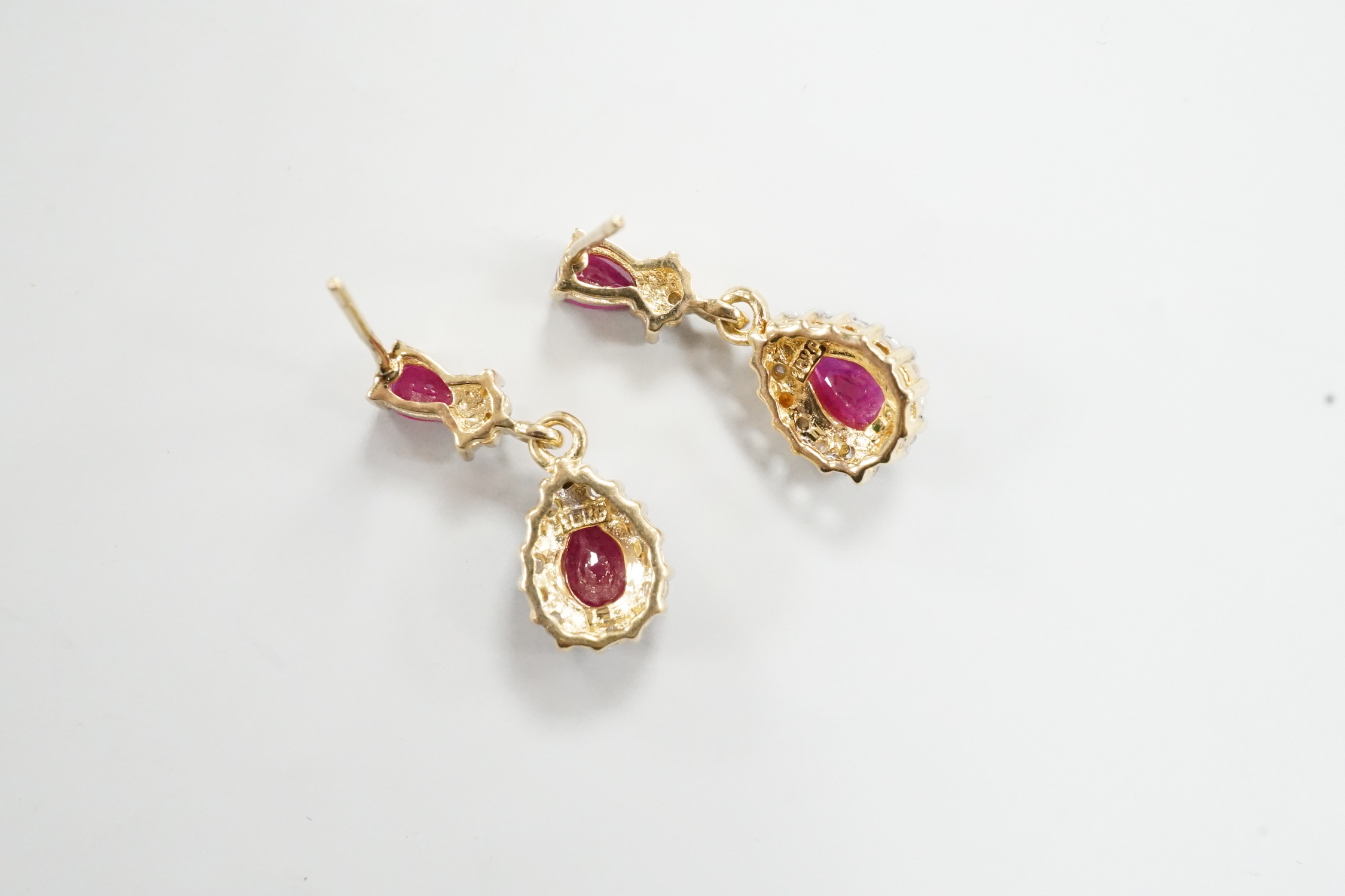 A modern pair of 18k yellow metal, ruby and diamond set pear shaped cluster drop earrings, 20mm, gross weight 3 grams.
